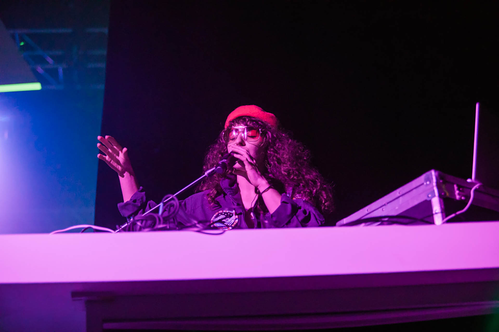Music photos live DFW; candid photo of a woman DJ performing and singing on stage.
