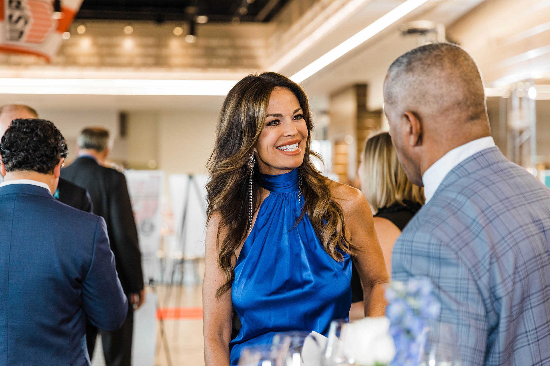 Dallas Commercial Photography of a smiling Caucasian woman in a blue dress at a corporate event.