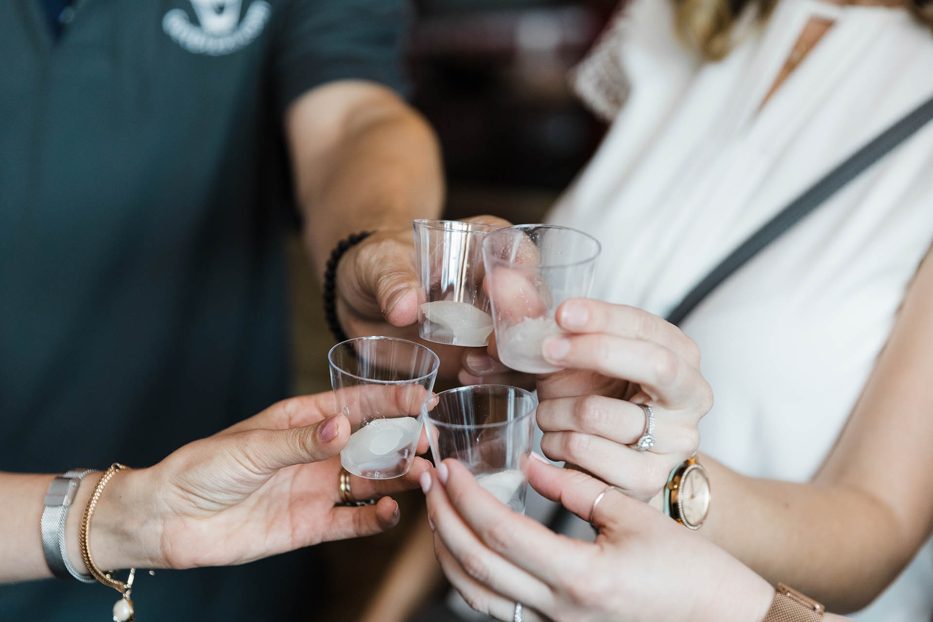 Fun Dallas event detail photo of four shot glasses being clinked together for a cheers.