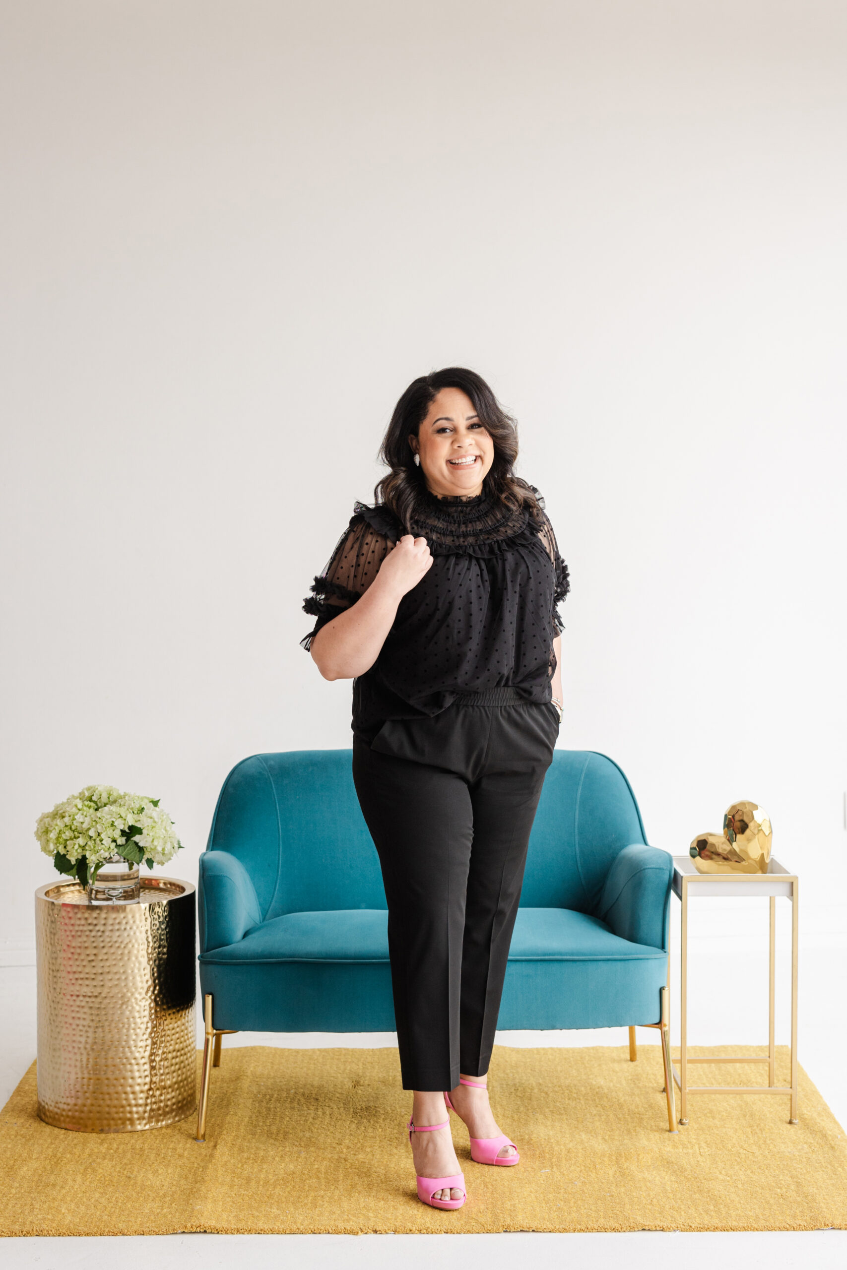 a woman taking business branding photos in a photography studio behind her is a blue sofa