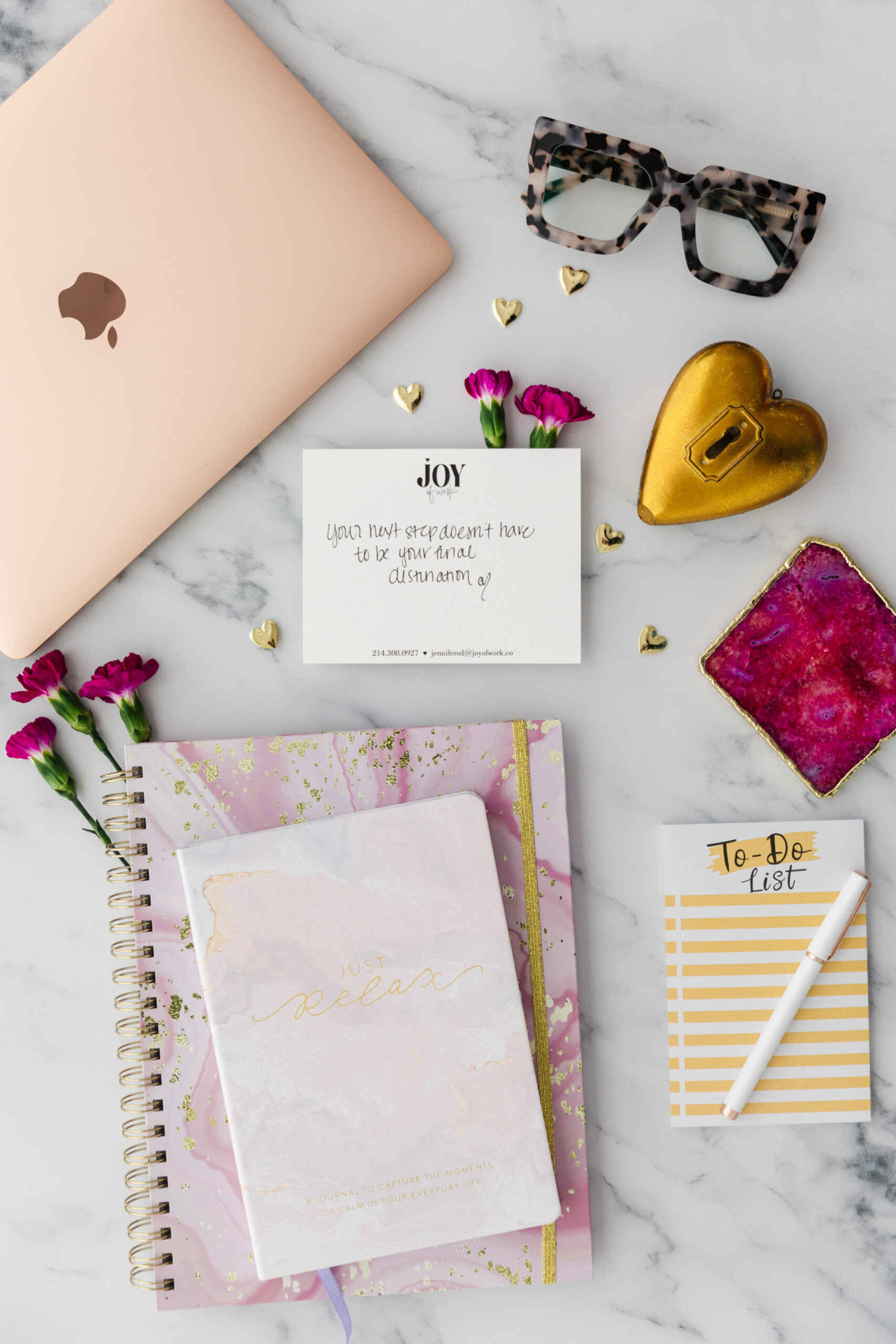a flat lay with a notebook, notecards, a laptop, and journals