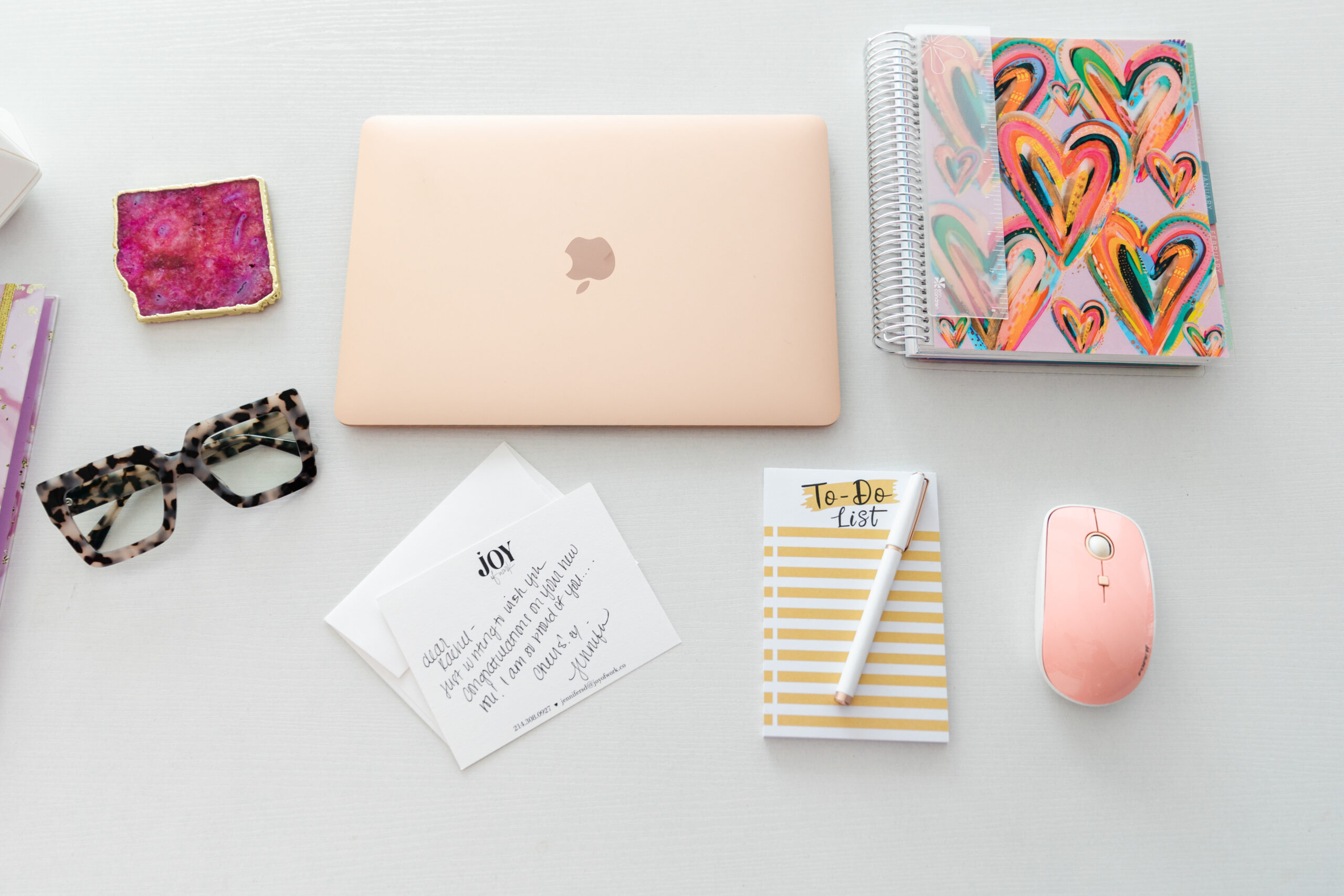 a flat lay that includes a notepad, laptop, glasses, and notecards