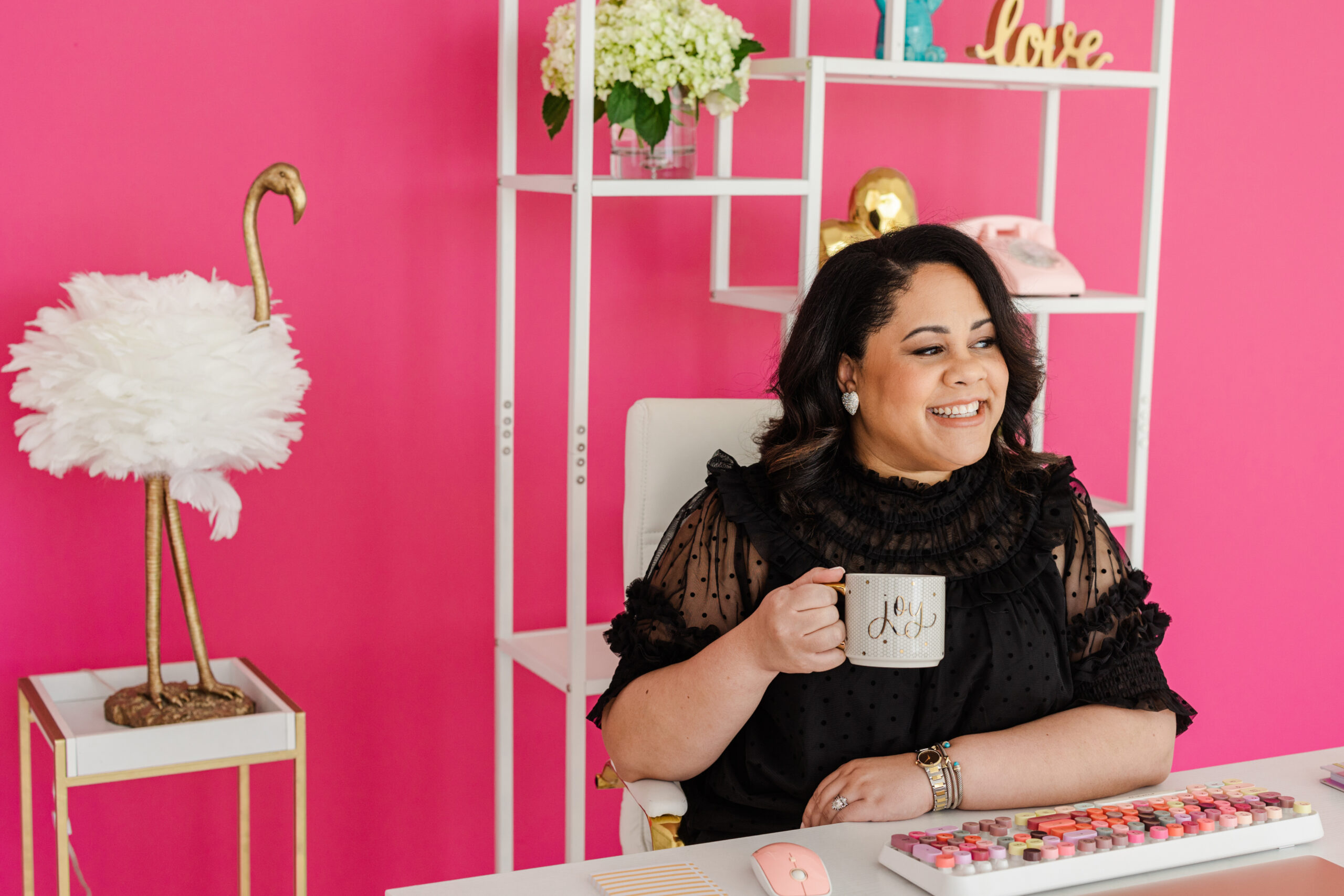a woman sitting at a desk holding a coffee mug during a professional business branding session
