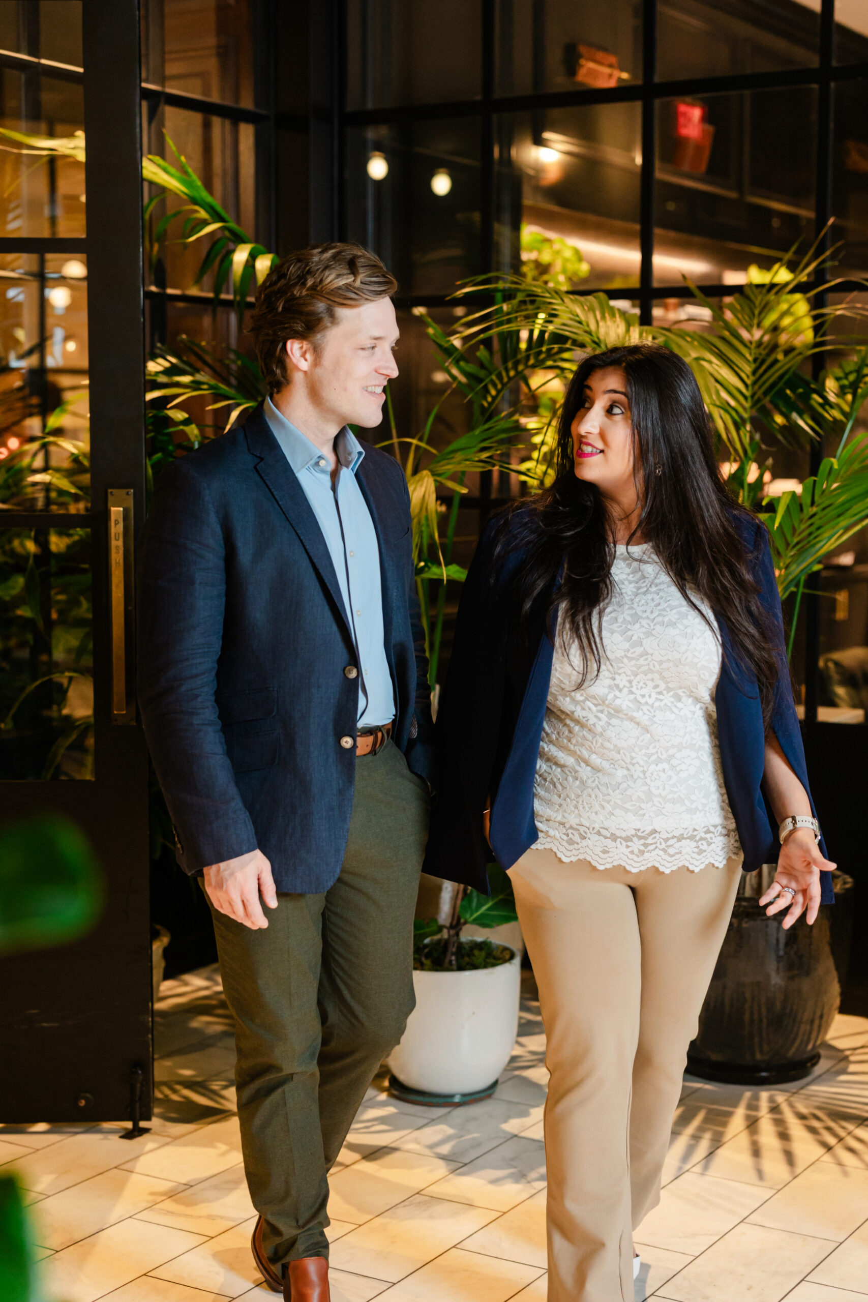 two co workers walking through the lobby of the adolphus hotel and conversing together 