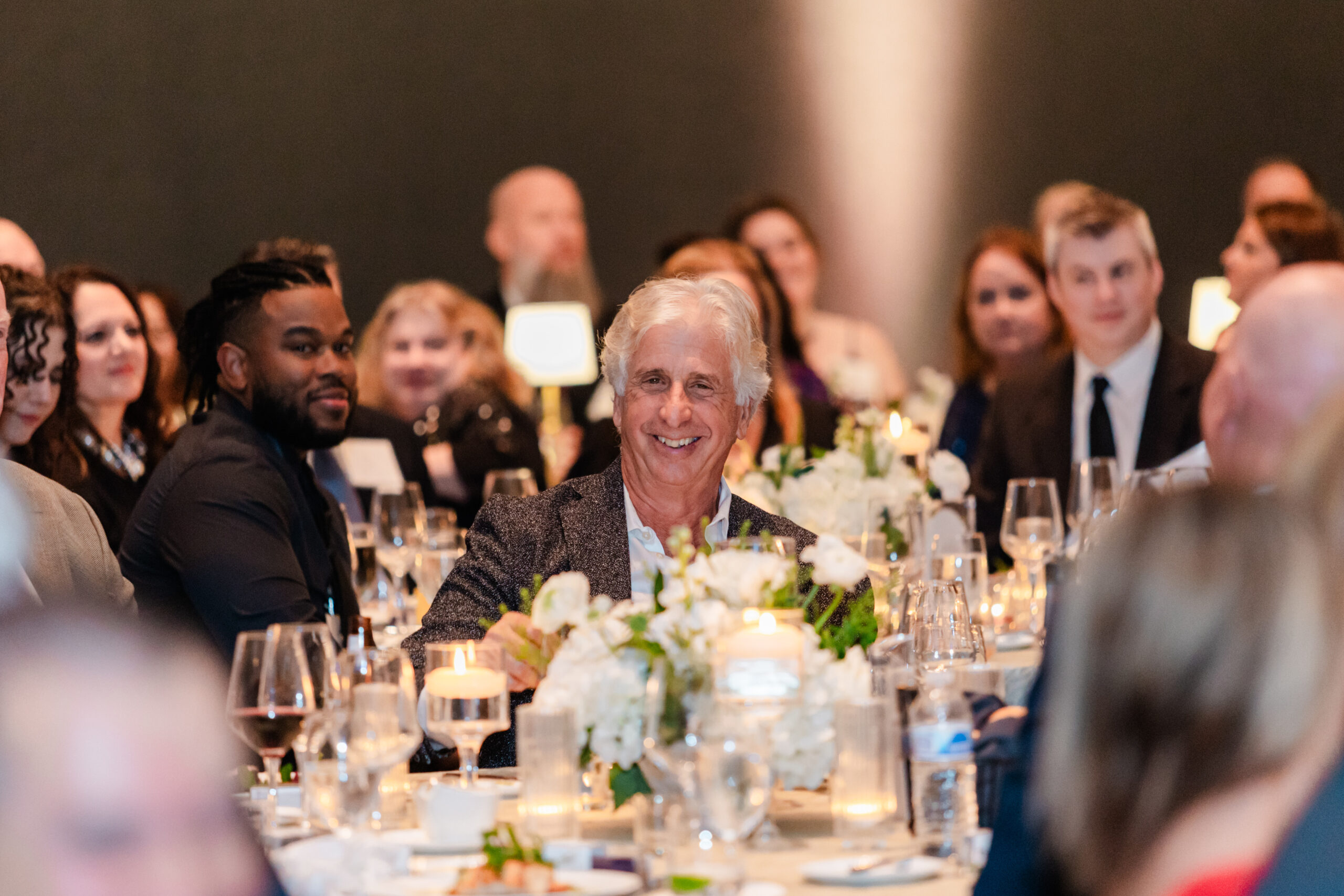 people laughing at a dinner table for a corporate event