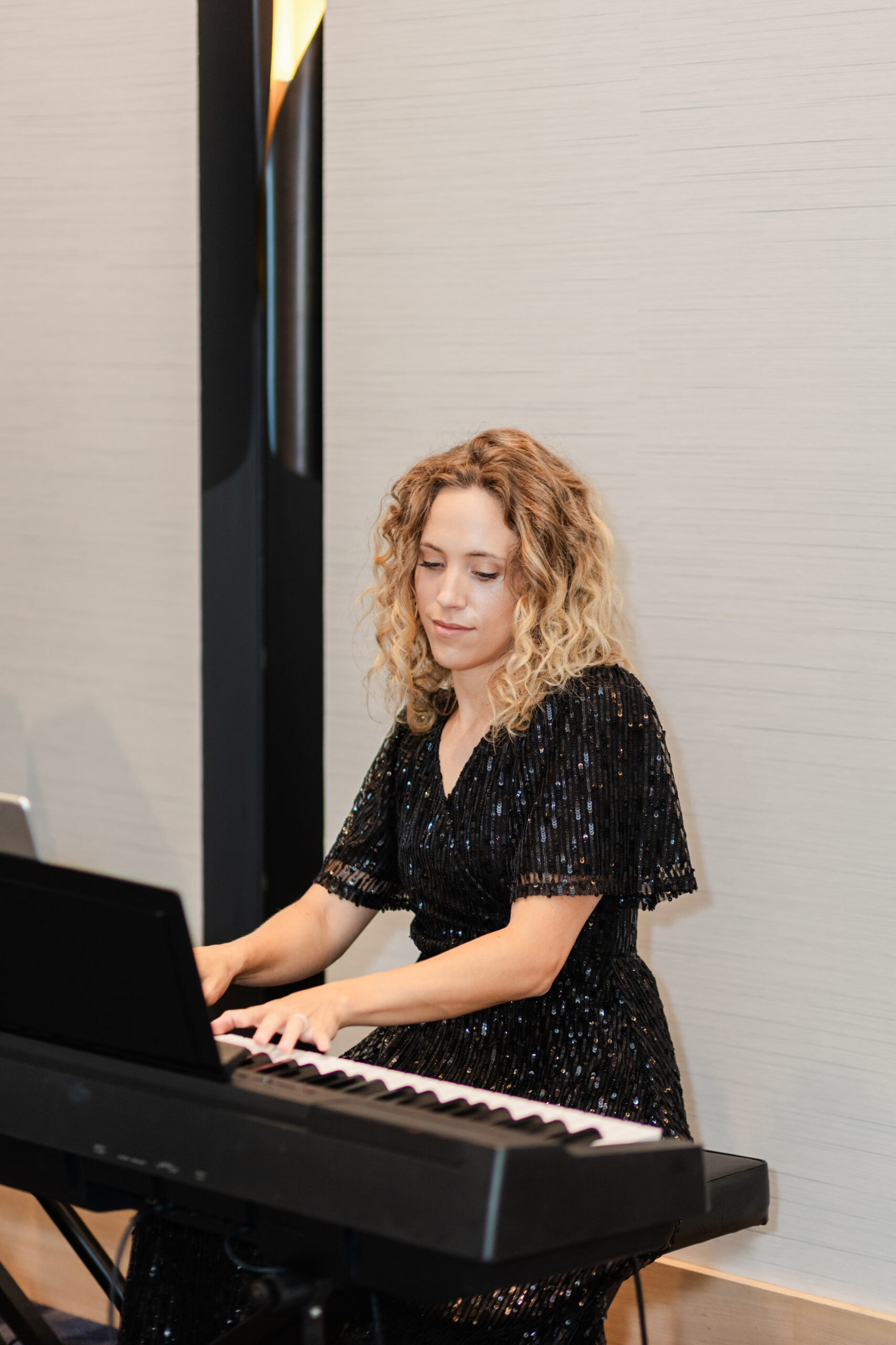 a woman playing the piano at a corporate event