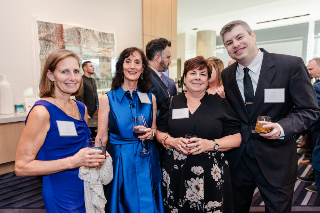 a group of people standing and smiling together at a corporate event in dallas