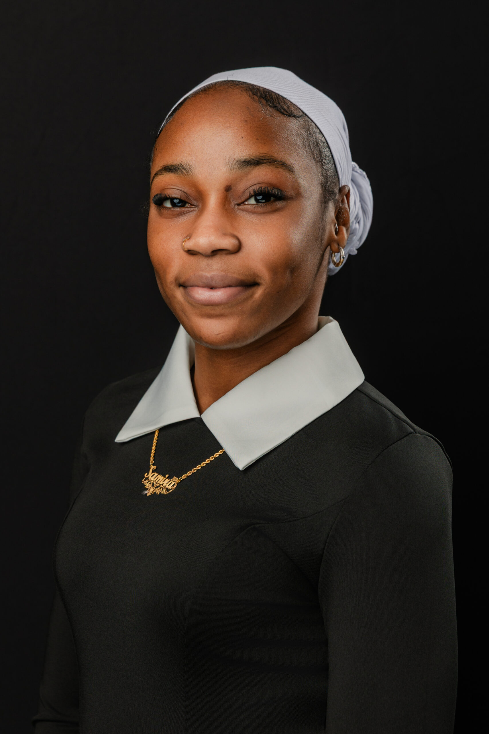 a woman taking corporate headshots in dallas against a black backdop 