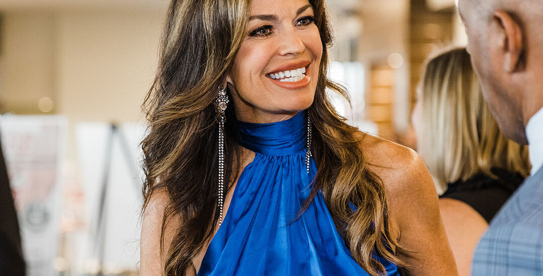 Dallas Corporate Event Photographer. Photo is of a smiling Caucasian woman in a blue dress at a corporate event.
