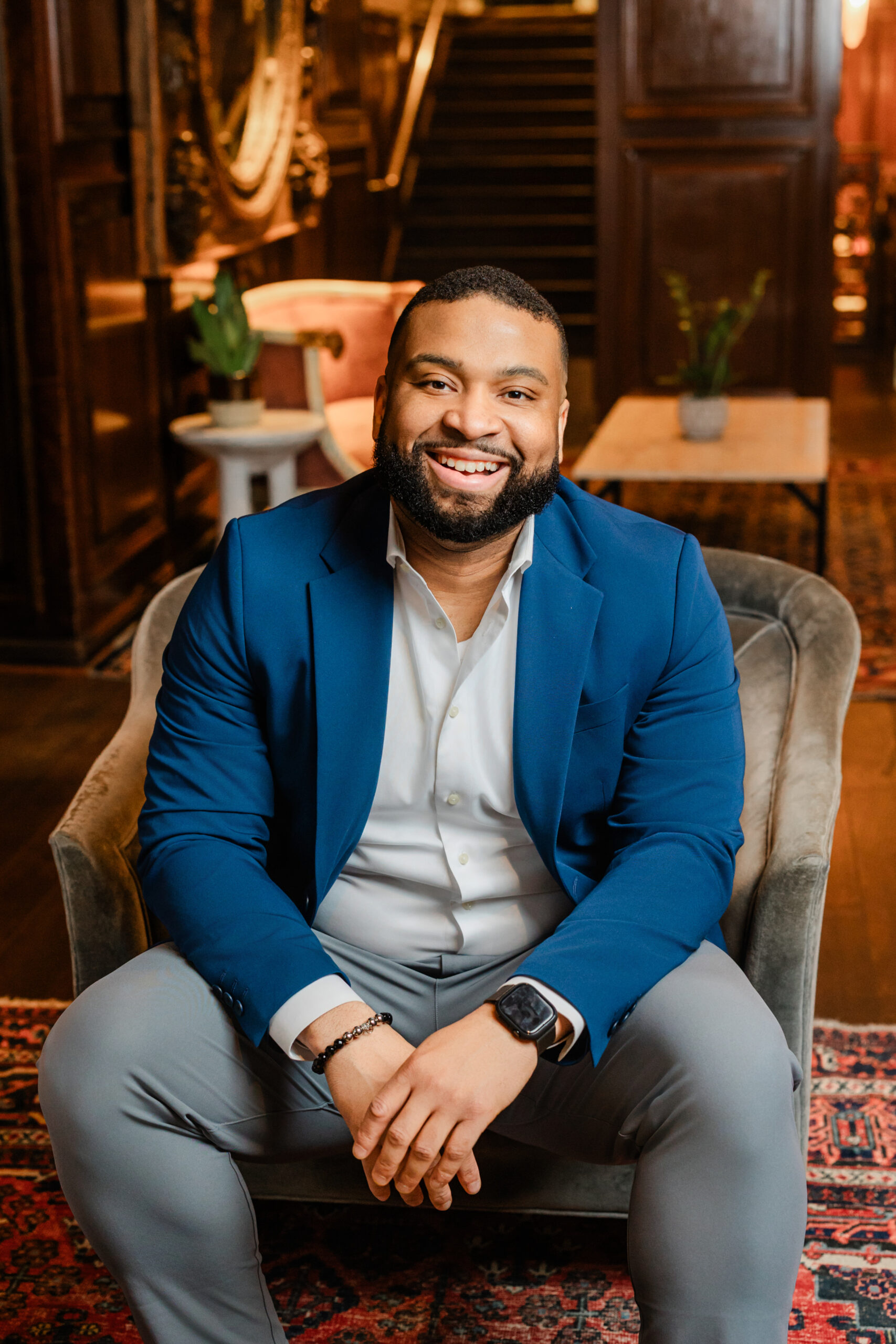 a man taking a formal corporate headshot sitting on a chair 