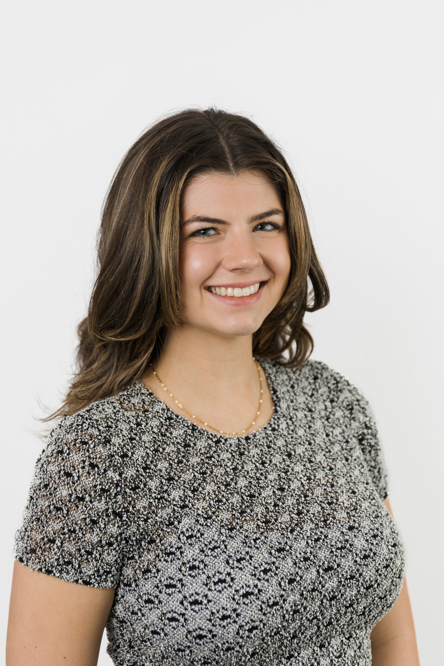 a woman taking a professional headshot in front of a white backdrop 