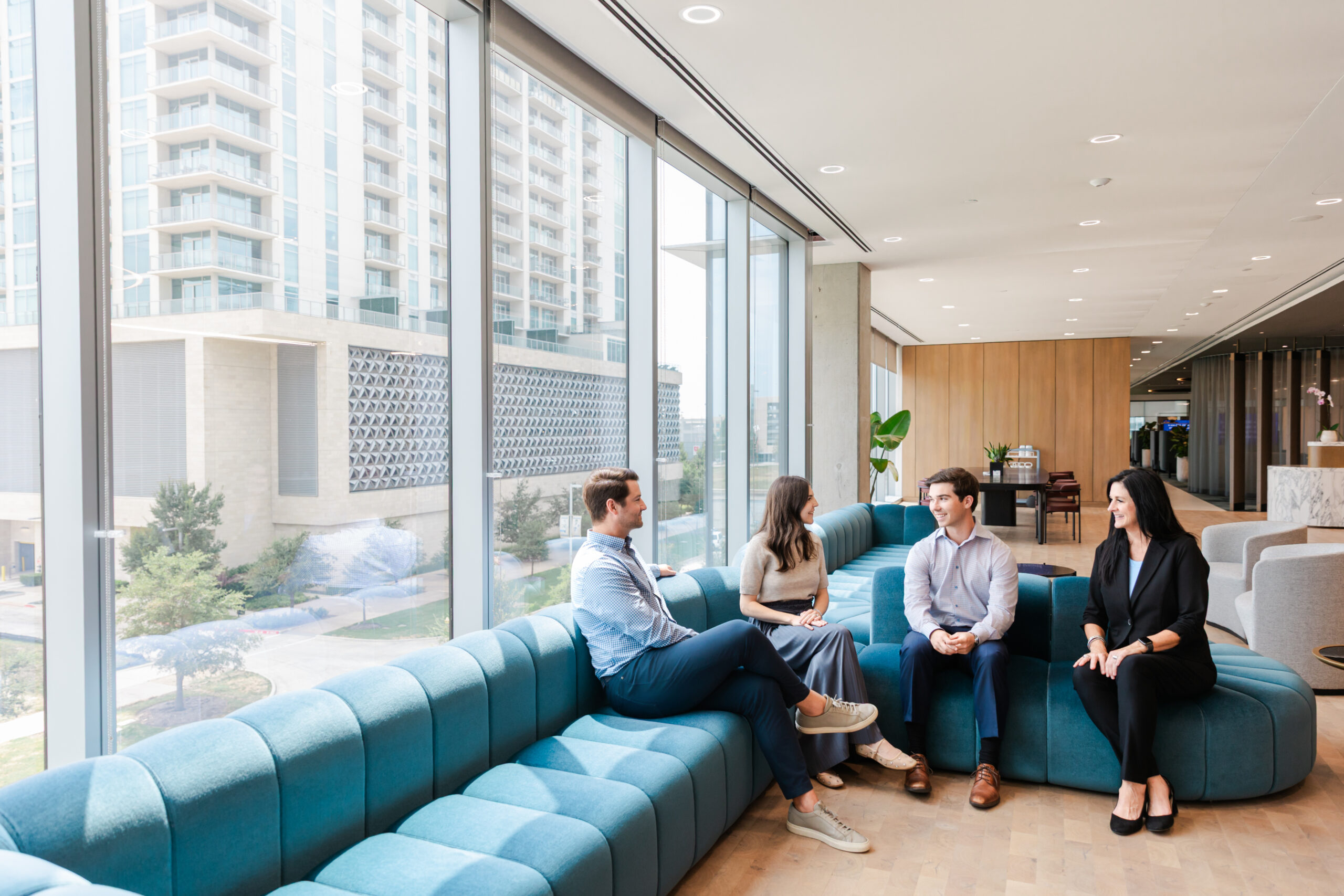a group of coworkers sitting on a blue couch in the ndp office building in dallas