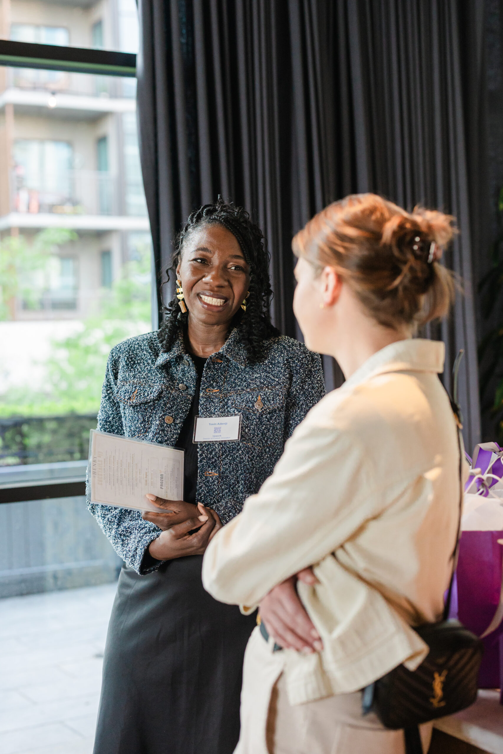 two women speaking to each other at a corporate event
