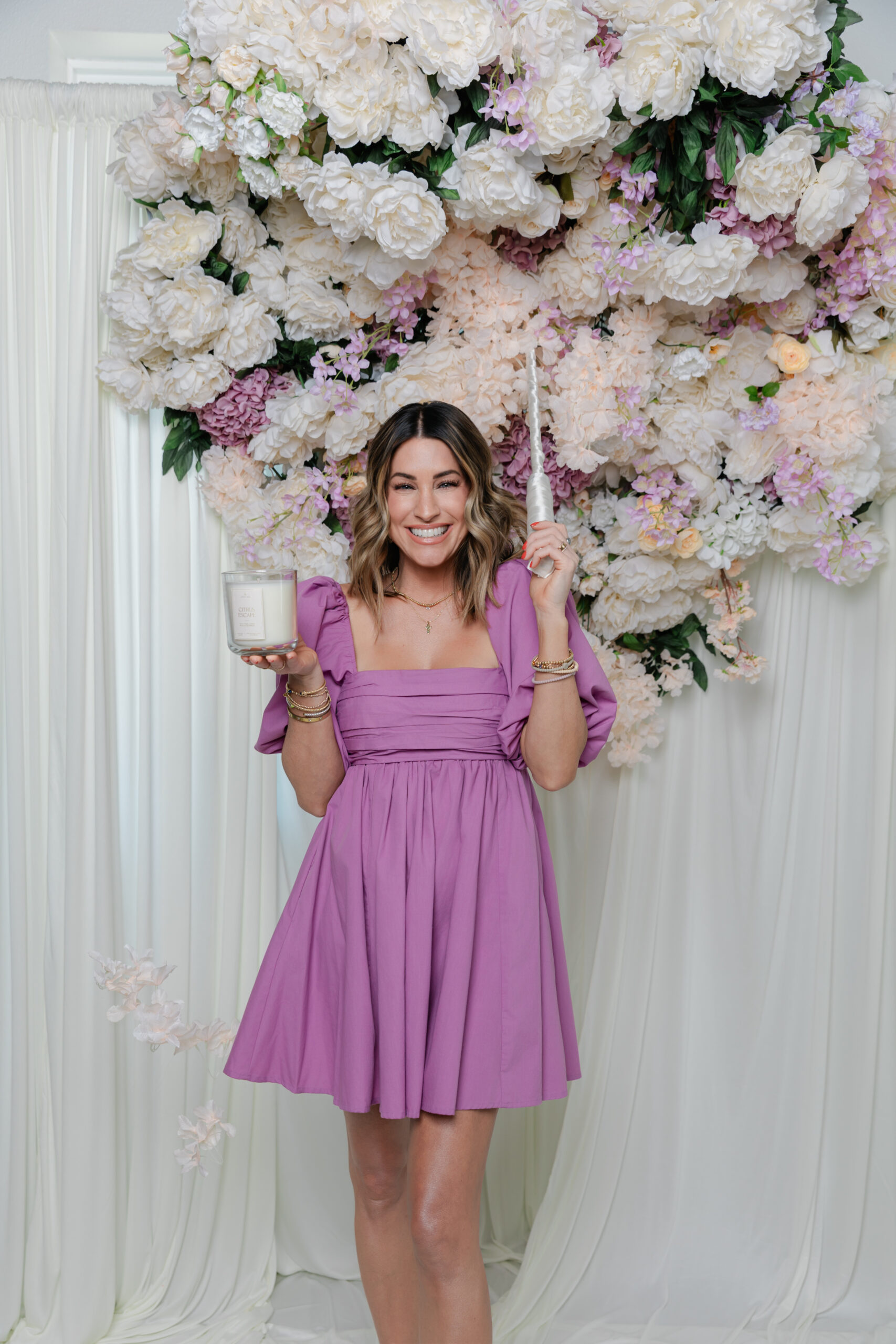 the founder of Life In Lilac holding one of their candles and a lighter 