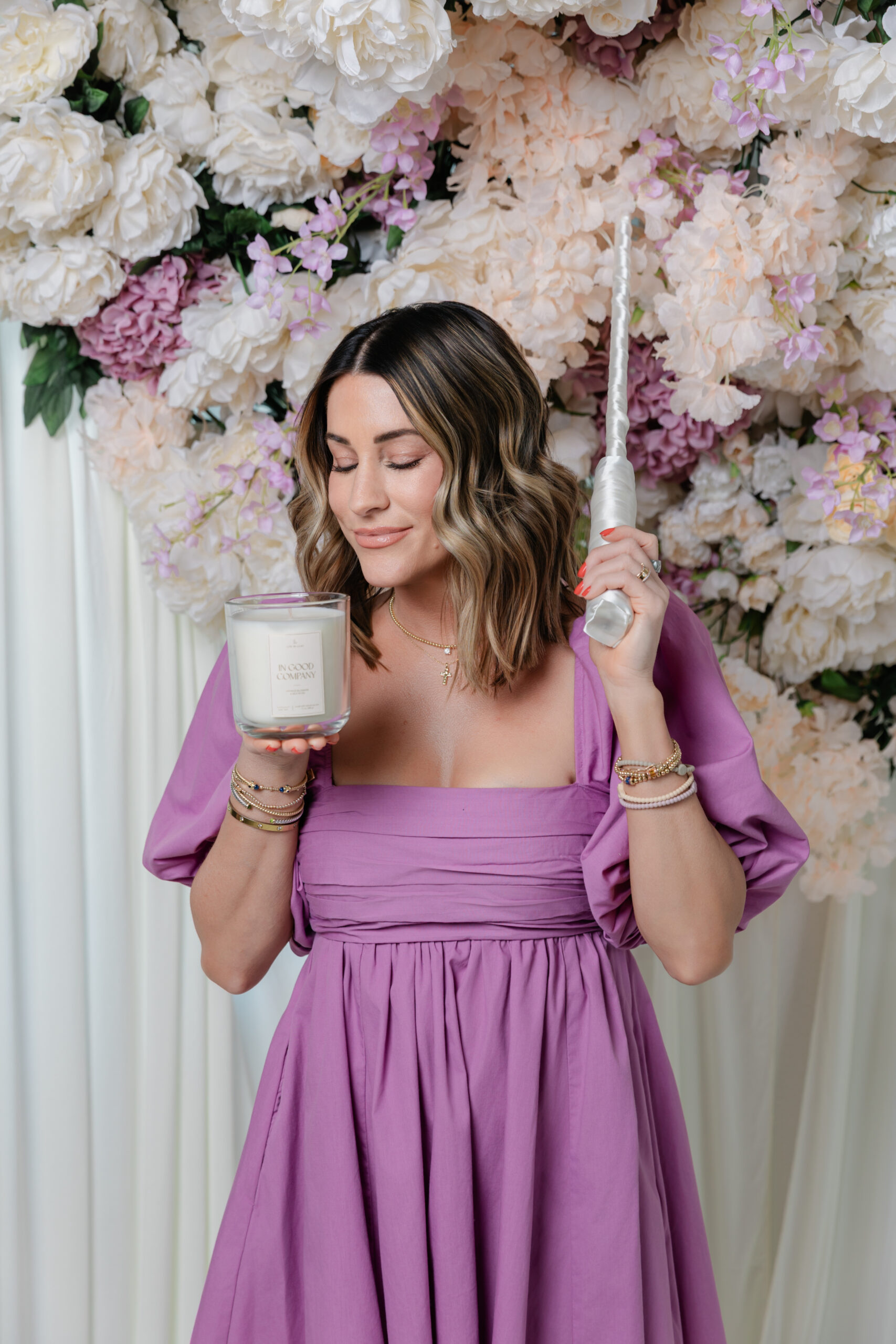 the founder of Life In Lilac holding on their candles and a lighter 