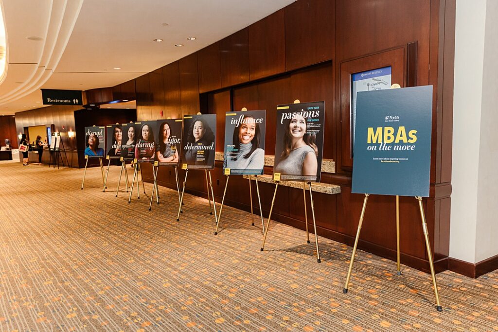 Detail shot of motivational posters at the Forte Foundation's MBA Women's Leadership Conference in Dallas, Texas. All of them are Forte branded and feature head shots of women with words like "passions," "influence," and "determined" written on them. 