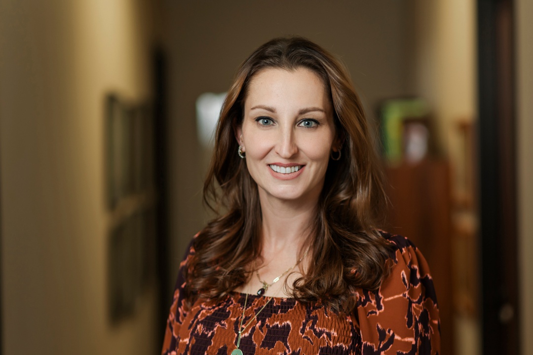 A smiling woman posing for a portrait in her office