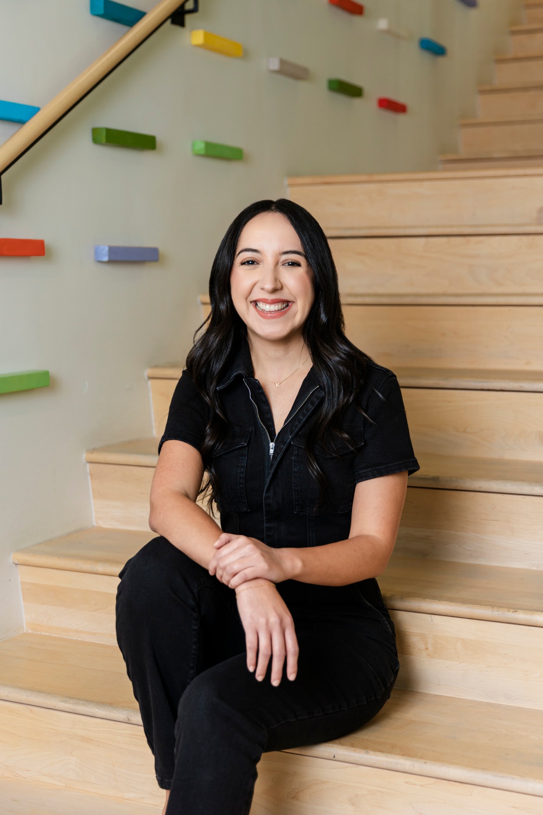 A smiling woman sitting on a staircase