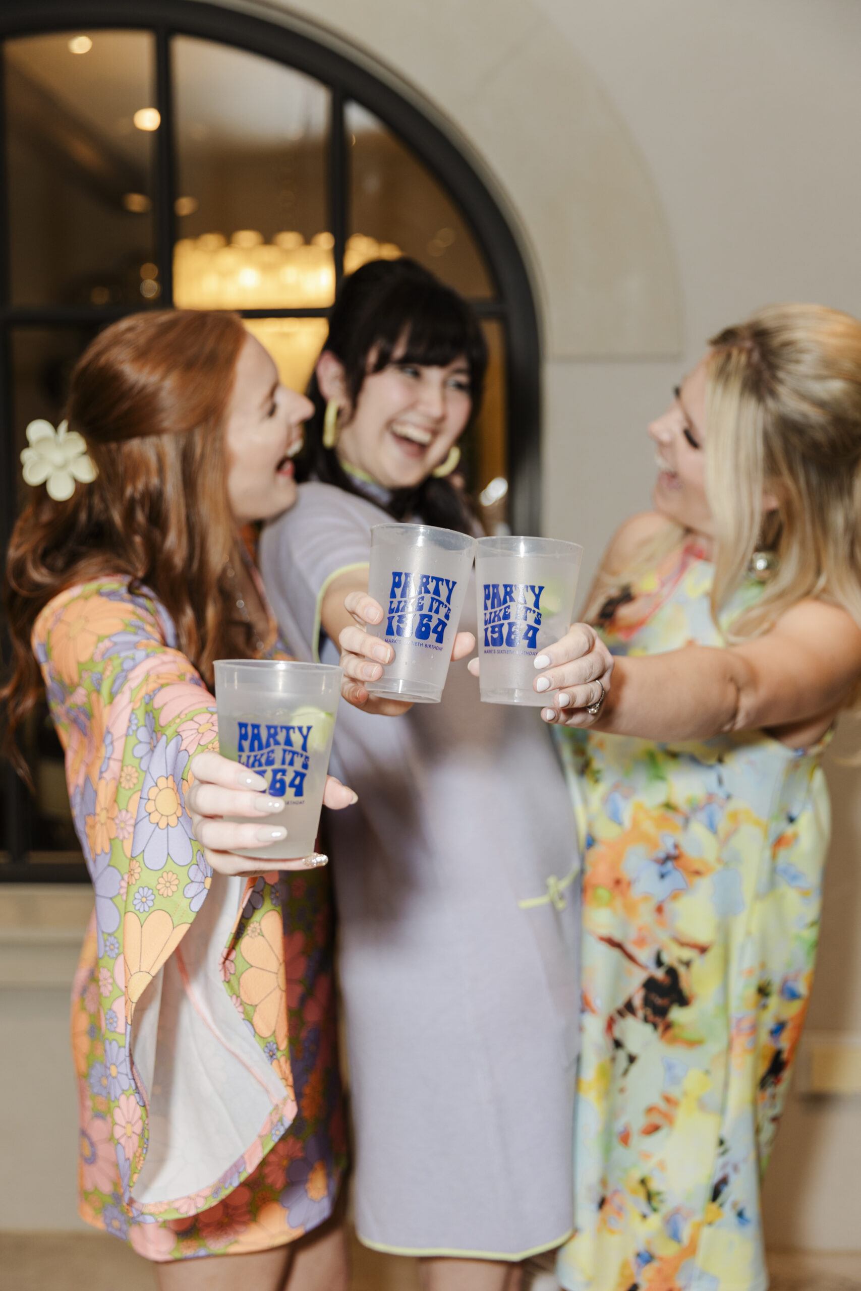 a group of woman clinking their glasses and laughing