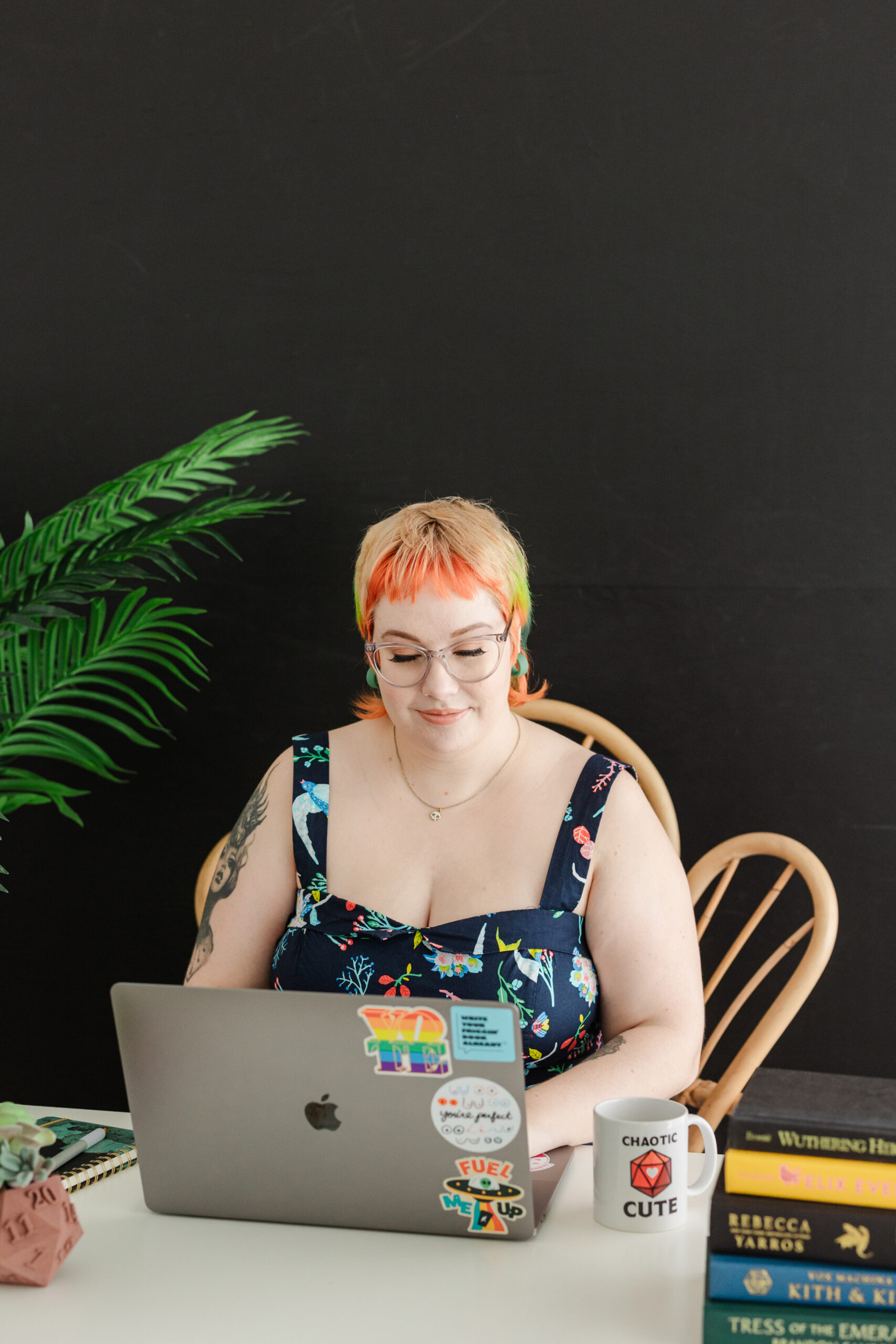 an author taking personal branding photos at new light studio in bedford texas she is sitting at a desk and typing on a computer