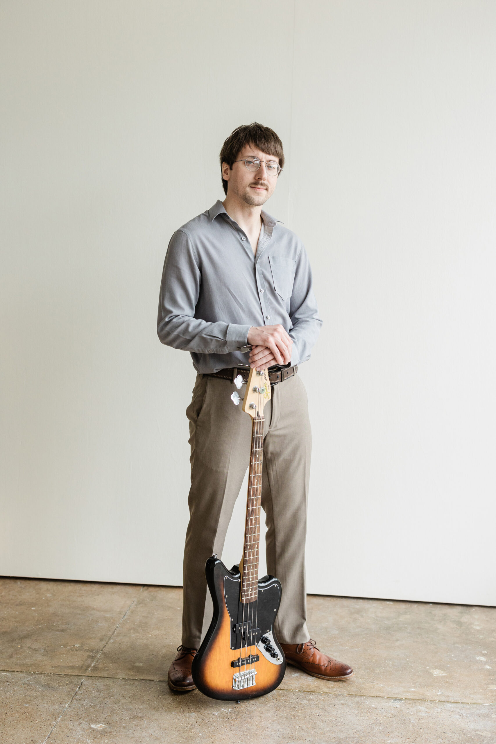 a musician taking branding photos at the space on south side in dallas texas with his guitar 