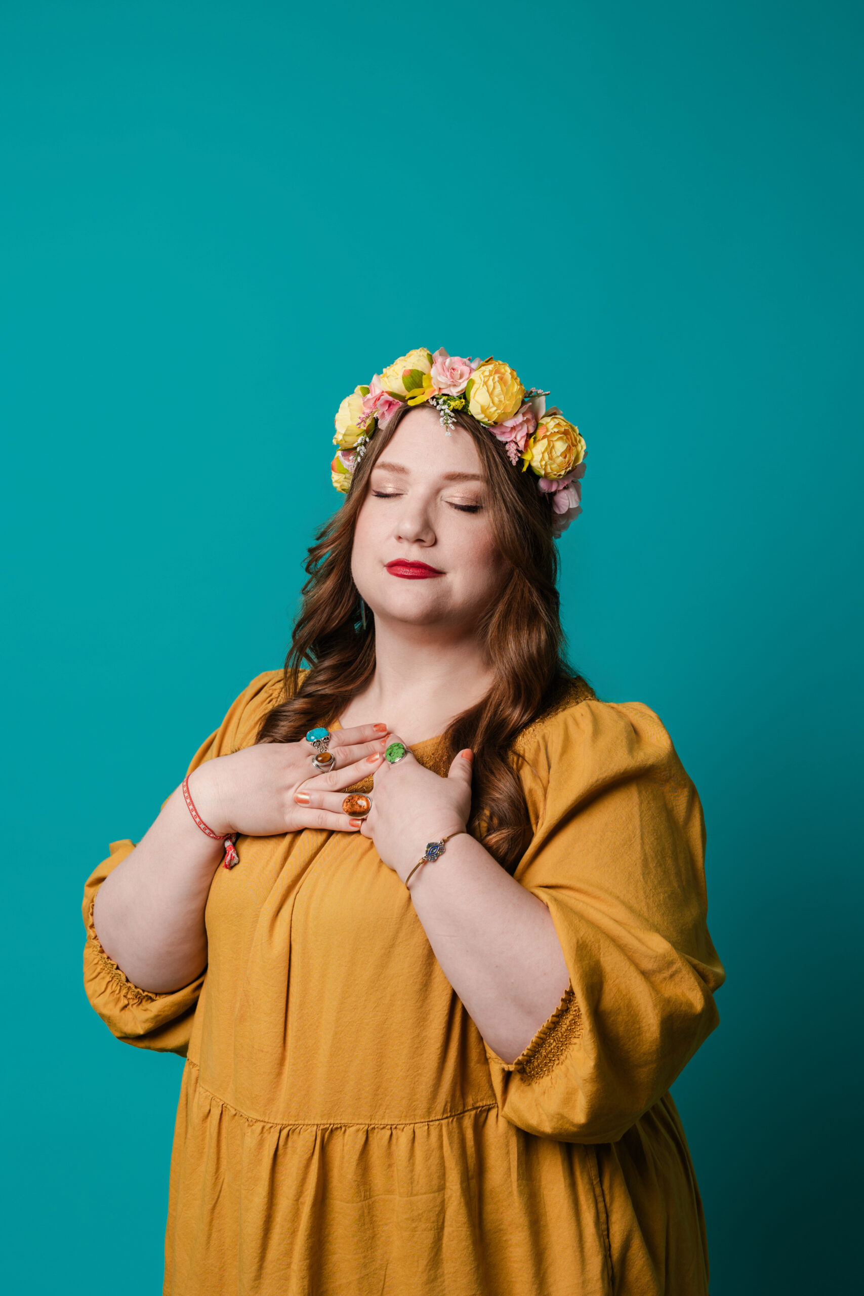 a woman wearing a yellow dress and flower crown taking a professional headshot