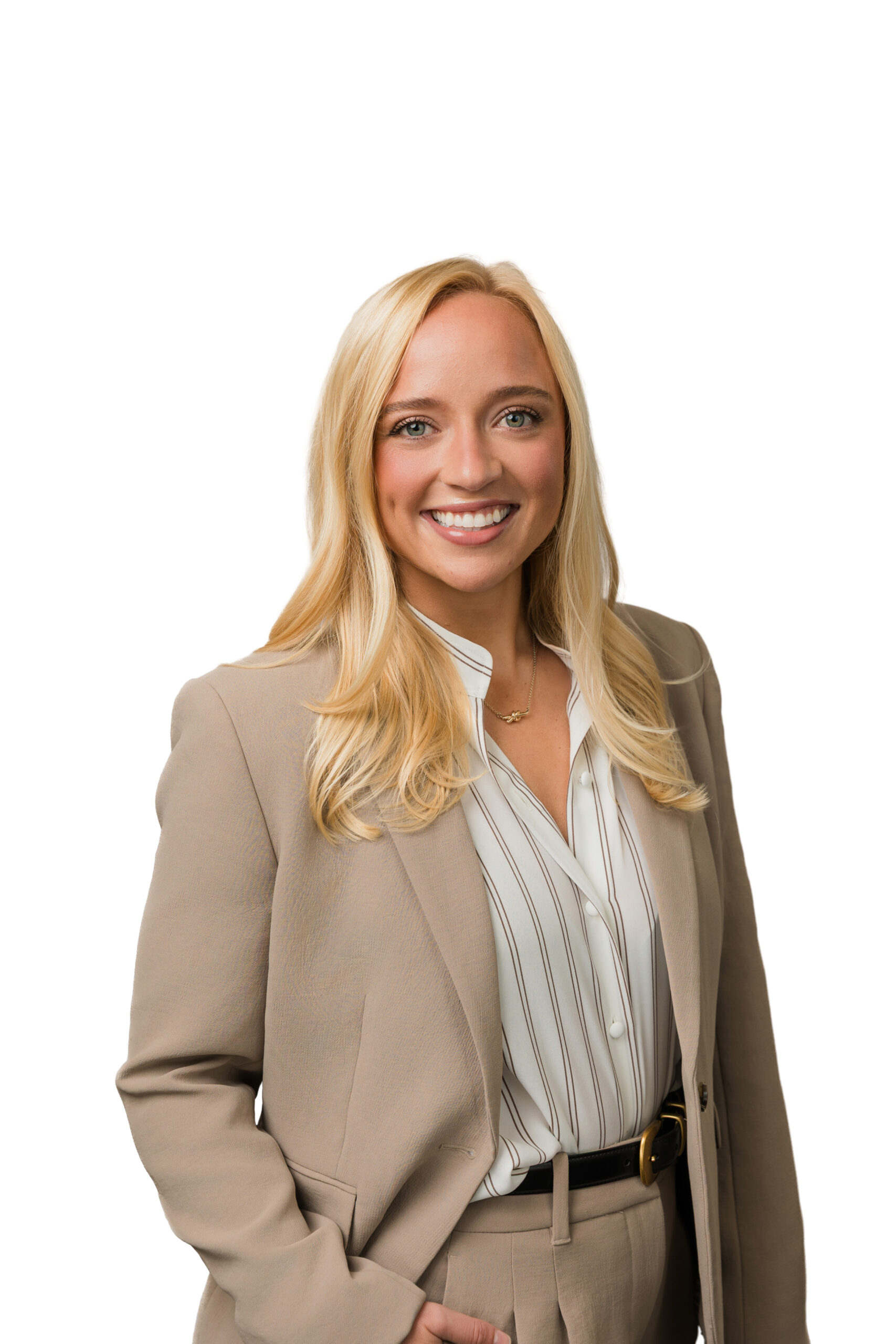 a woman in a striped white button up and brown blazer taking a headshot against a white backdrop 